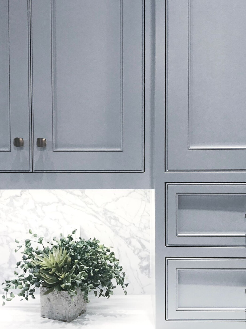 A kitchen with bespoke front door and olive green joinery.